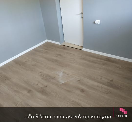 רצפת פרקט עץ בחדר עם קירות אפורים